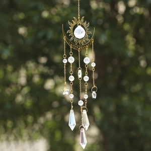 Detailed close-up of golden sun and moon suncatcher with AB crystal prisms in nature