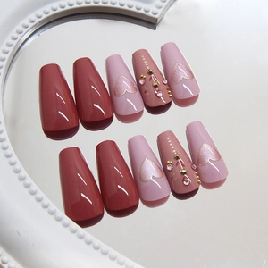 Pink and rose red coffin press-on nails with rhinestone hearts on a pearl mirror tray