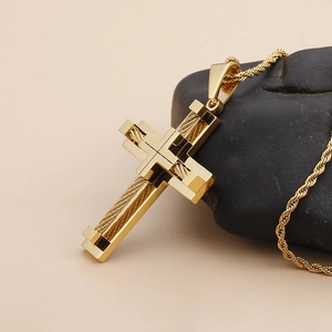 Macro view of golden steel cross necklace with cable texture on dark stone base