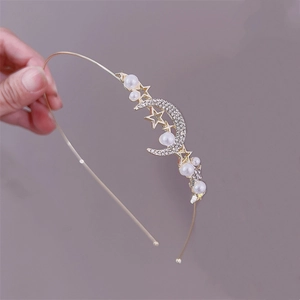 Close-up of golden headband with pearls, rhinestone moon and star charms detail