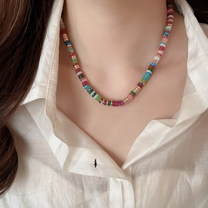 Close-up of vibrant 18k gold plated multi-colored beaded necklace on a model's neck