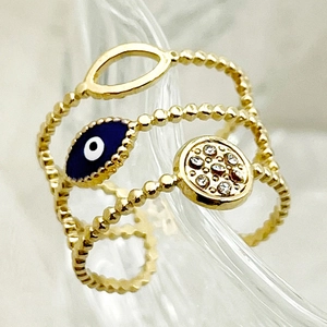 Detailed view of a gold beaded evil eye ring with blue enamel and sparkling crystal pavé