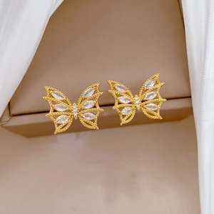 Détail de boucles d'oreilles papillon dorées avec zircons marquise et micro-diamants