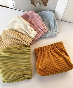 Flat lay of colorful corduroy cosmetic bags with squeeze closure in six soft pastel colors