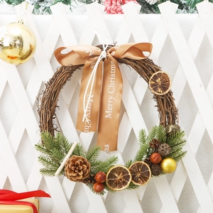 Natural vine Christmas wreath with pine cones and orange slices on a white wooden fence