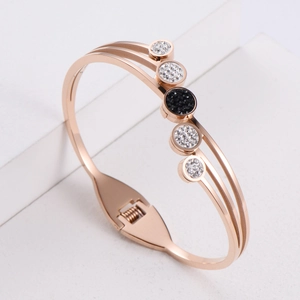 Elegant rose gold three-layer stainless steel bangle featuring sparkling black and white crystals
