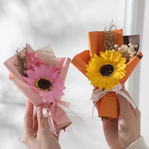 Close-up of handmade mini sunflower bouquets in pink and yellow with decorative ribbons