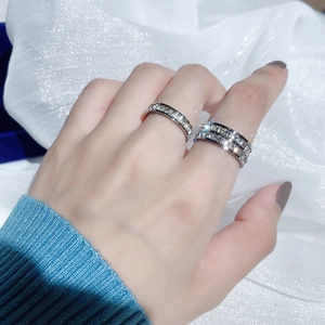Close-up of single and double row diamond rings on a finger with metallic luster