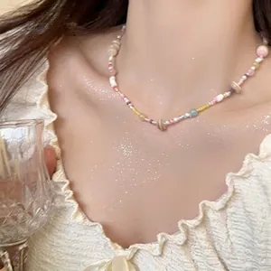 Detailed view of colorful beaded necklace with pink yellow and white pearls on model neck