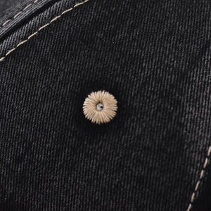 Macro shot of embroidered ventilation eyelets and twill texture on a cotton baseball cap