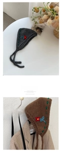 Detail of hand-knitted floral headband with contrast stitching and embroidery
