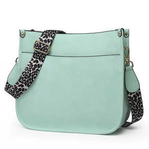 Detail of mint green PU leather tote bag with a leopard print adjustable wide shoulder strap