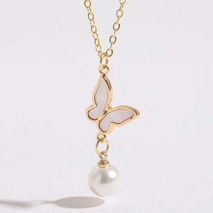 Macro d'un collier plaqué or 14K avec pendentif papillon en nacre et perle blanche