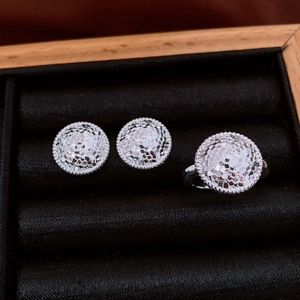 Détails d'une parure en argent avec boucles d'oreilles et bague dans un écrin noir
