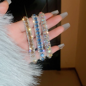 Three-piece sparkling geometric diamond bracelets in amber, royal blue, and aurora hues