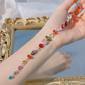 Close-up of rainbow crystal bracelet featuring diverse gemstone cuts on silver base