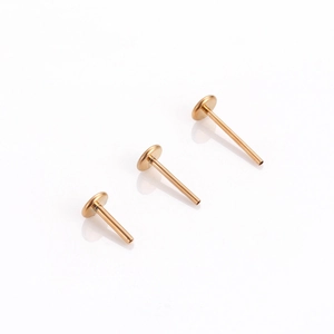 Detailed view of three gold G23 titanium flat disc push-pin labret studs in various lengths