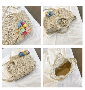 Detail view of woven straw beach bag featuring colorful tassels and drawstring lining