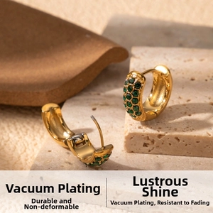 Detail of vacuum-plated gold hoop earrings with emerald green zircon and micro-inlay stones