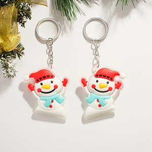 Close-up of two cute Christmas snowman keychains with red hats and blue scarves