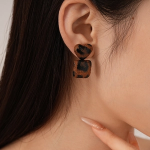 Detail view of retro leopard print heart and square earrings with textured finish