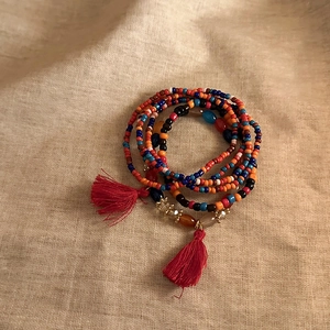 Bohemian multi-layer seed bead bracelet with vibrant colorful beads and red tassel