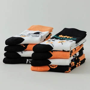 Halloween crew socks featuring pumpkins bats and ghosts on orange and black knit fabric