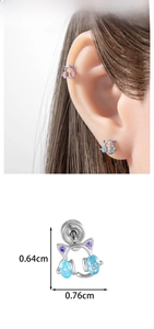 Detailed close-up of cute kitten ear studs with blue and pink gems for cartilage piercing