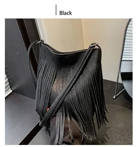 Detail of black pebbled leather bucket bag with long fringes and slender shoulder strap