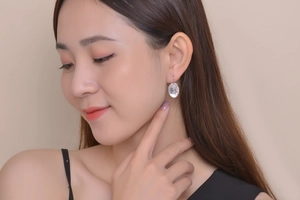 Silver oval drop earrings with clear gemstones worn by a model for a stylish look