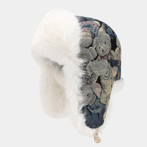 Dettaglio del cappello invernale floreale con fodera in ecopelliccia bianca e paraorecchie
