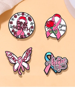 Makro-Detail von vier verschiedenen Emaille-Pins mit rosa Schleife und Blumen-Design