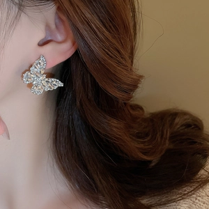Macro view showing elegant silver butterfly stud earrings with sparkling cubic zirconia