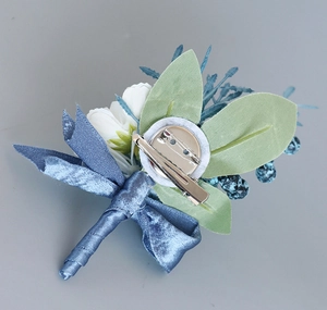 Detail of white rose boutonniere featuring the dual pin and clip attachment system