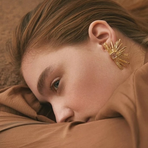 18k gold plated sunburst earrings with red cat eye stone shown on a female model