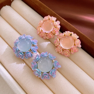 Detailed macro view of French vintage floral earrings with rose carvings and gems