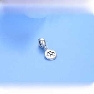 Macro shot of 925 sterling silver charm pendant featuring an engraved pet paw print detail