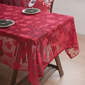 Detailed view of red lace Christmas tablecloth with festive reindeer and tree patterns