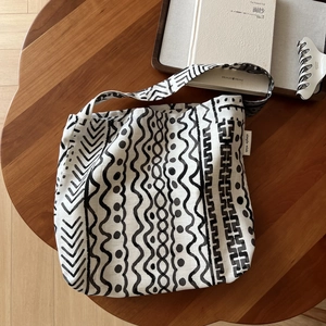 Artistic bohemian linen bag with geometric prints on a dark wood table background