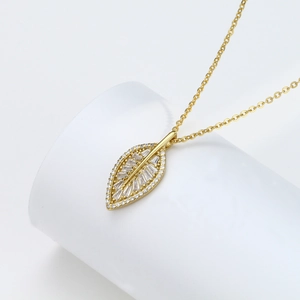 Detail of s925 silver leaf pendant with micro-pave zircons and golden finish chain