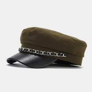 Detail of army green canvas baker boy hat with black leather brim and chain trim