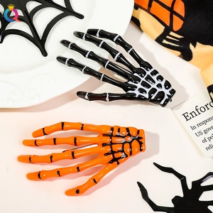 Detail of Halloween skeleton hand hair clips in black and orange on festive background