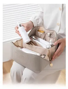 Detailed interior of a beige vertical striped cosmetic bag with organized makeup compartments