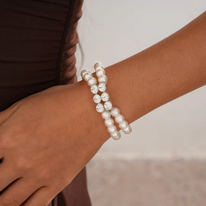 Close-up of double-layer pearl bracelet with rhinestone accents worn by a model