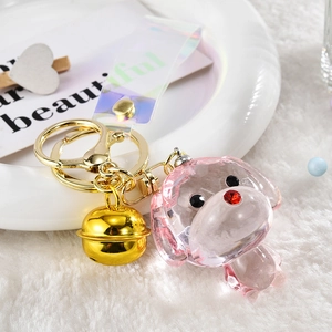 Detail of pink crystal acrylic dog keychain with gold bell and holographic strap