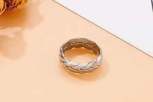 Macro di un anello in metallo argento con trama intrecciata e design artigianale retrò