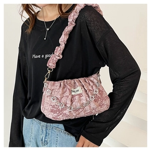 Pink cloud bag with flower chain strap and ruffle edge detail worn by a model