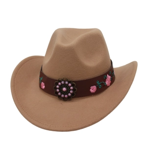 Detail of western felt cowboy hat with embroidered floral leather band and pink bead accent