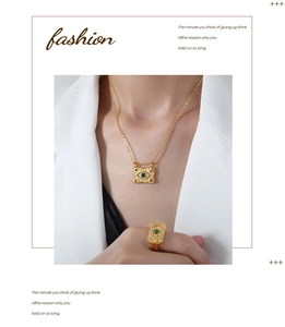Fashionable model wearing gold evil eye necklace and ring set with green gemstones