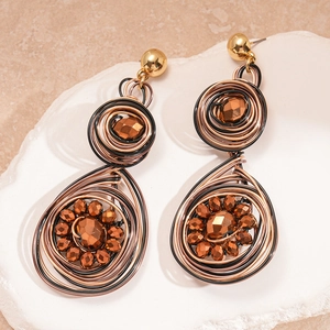 Close-up of retro geometric earrings with woven gold wire and brown faceted beads